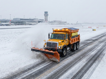 camion de déneigement sur une piste d'atterissage d'avions
